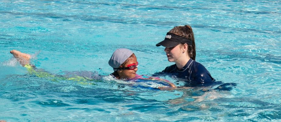 Child swimming with instructor
