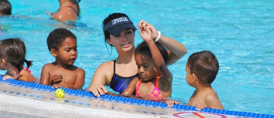 Swim Instructor helping a child with a swim stroke