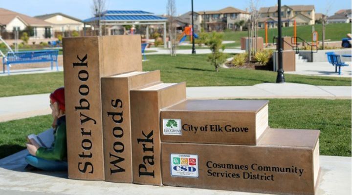 Large concrete books engraved with "Storybook Woods Park" and a gnome reading a book