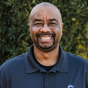 A preschool teacher smiles.